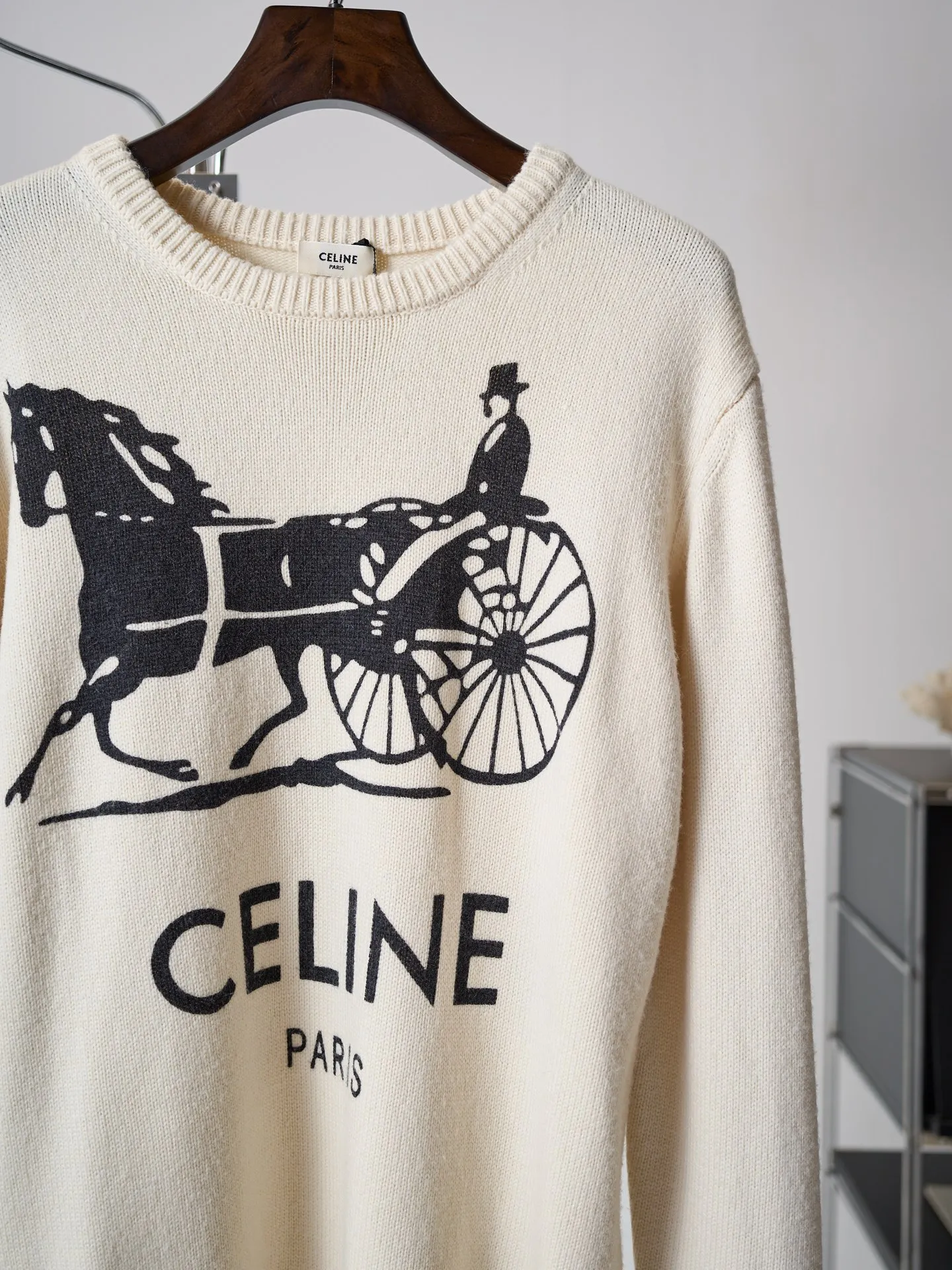 [Real object hanging] CELINE/Celine carriage print round neck knitted sweater [In Stock] S M L XL Fabric selection: Made of 62% wool + 23% nylon + 15% anti-pilling acrylic blended yarn, precision woven on an imported 7-needle knitting machine. The 7-needle medium-thick knitted structure makes the fabric fluffy and thick, with excellent temperature-locking ability; wool gives the fabric a soft, waxy and skin-friendly texture, while nylon strengthens the toughness and prevents it from loosening and deforming. It is paired with anti-pilling acrylic to give it both comfort and durability, and a solid texture. Printing process: The Classic carriage pattern and letters on the chest adopt a reactive printing process. The dye penetrates into the knitted fiber and is not offset printed on the surface. The pattern lines are clear and neat, and the touch is natural without a hard glue layer. It is not easy to crack or peel after repeated wear and washing, and the original soft texture of the knitted fabric is completely retained. Details: The round neck, cuffs and hem are made of high-density wide rib weaving, which has long-lasting elasticity and will not loosen easily after long-term wear; the back shoulders are made of hollow keyhole technology, and the entire line is evenly routed.